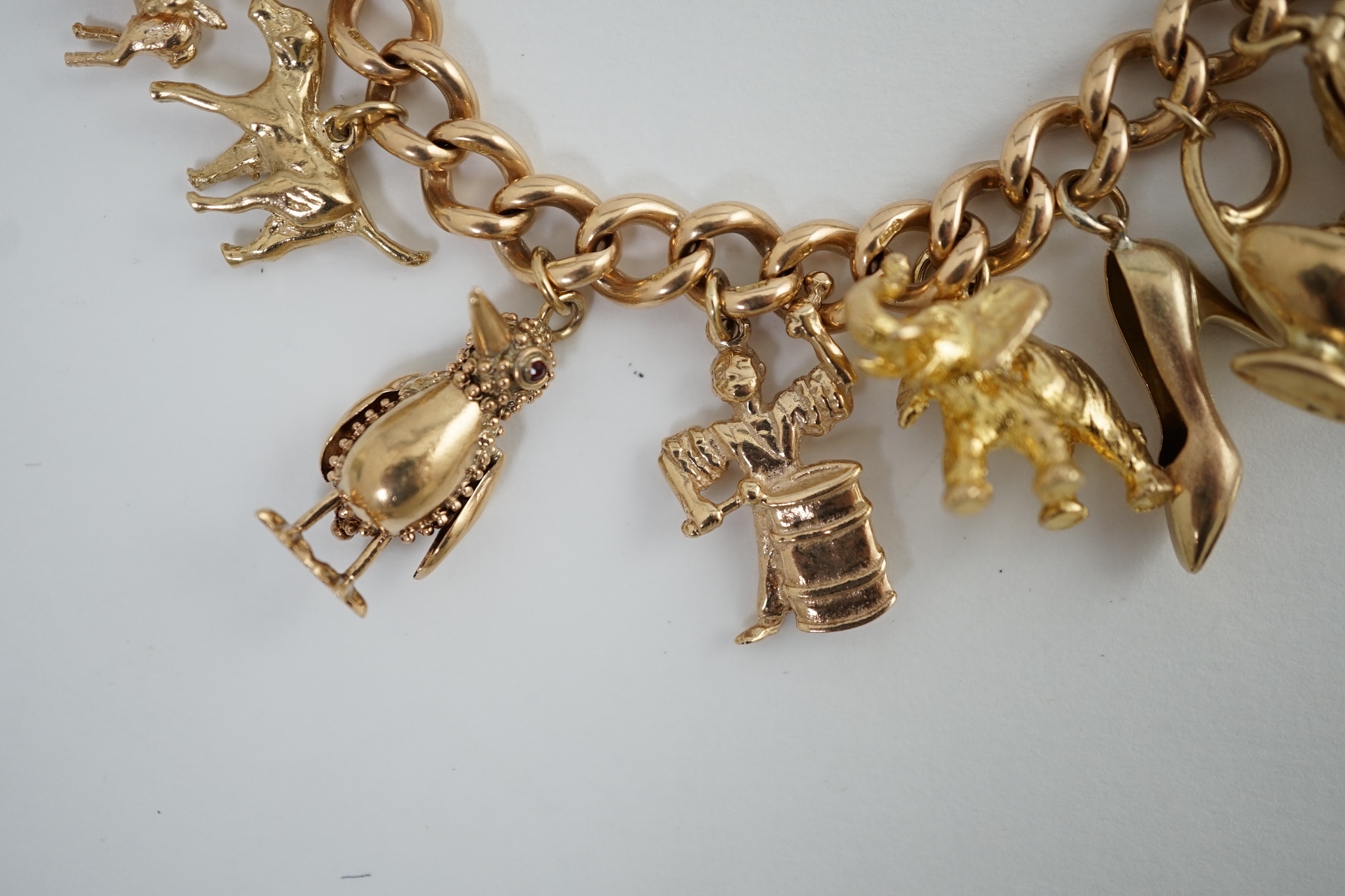 An early 20th century 15ct gold curb link charm bracelet